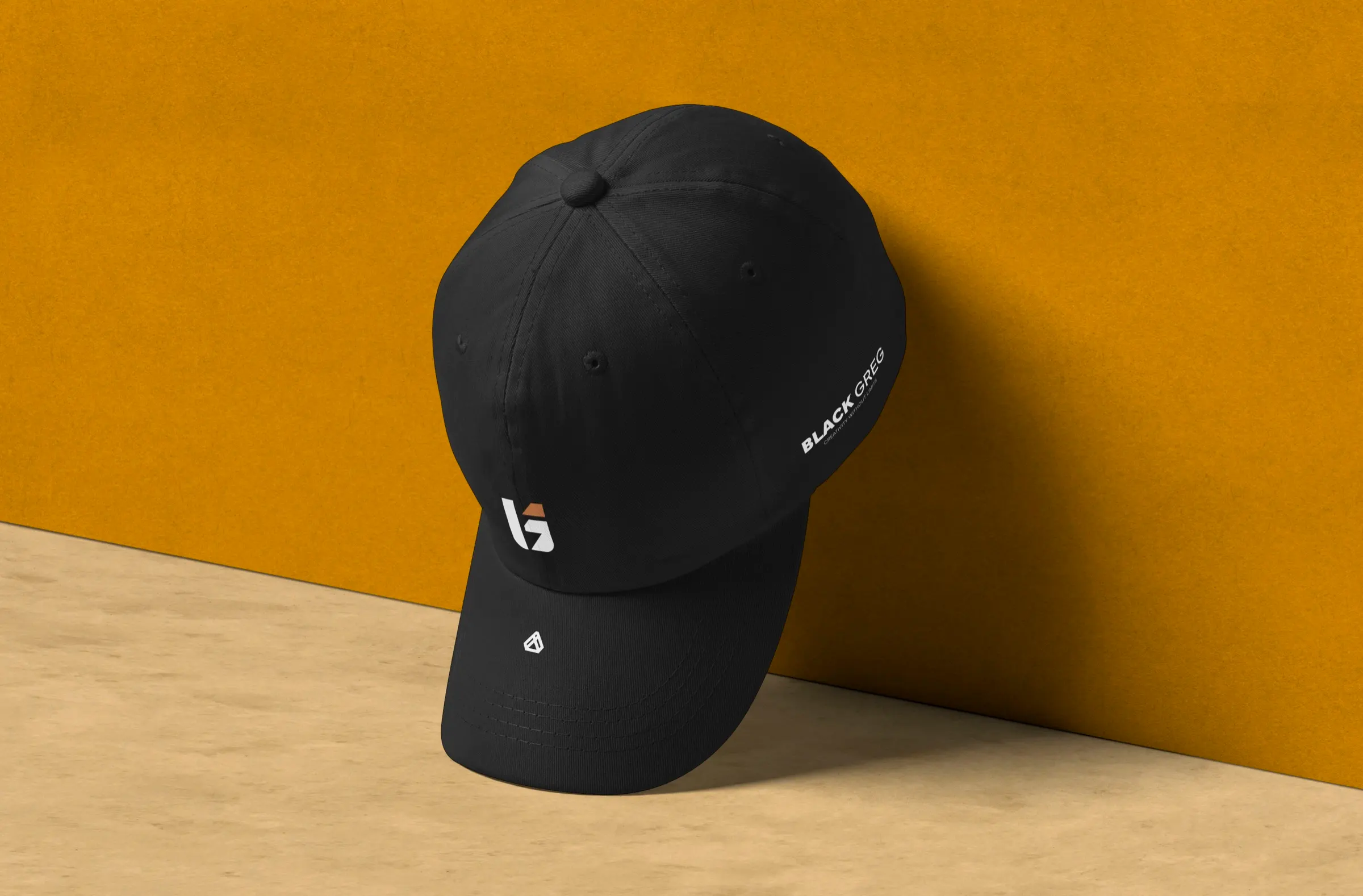 Black cap with The Black Greg monogram against an orange wall